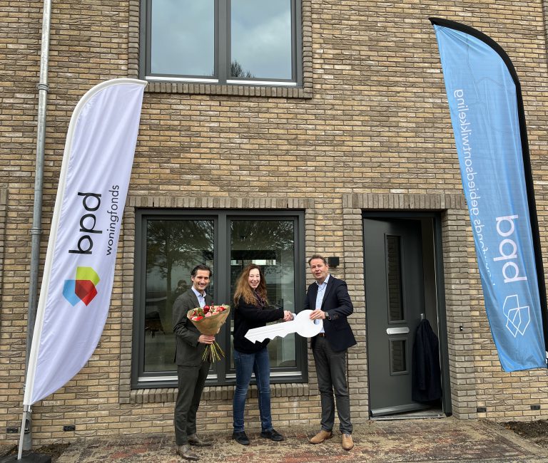 Foto 1 Een huurder ontvangt de sleutel van haar nieuwe middenhuurwoning
